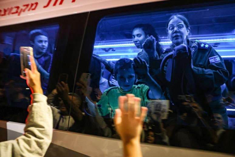 Reféns libertados pelo Hamas no domingo em um ônibus que os transporta para uma base militar em Ofakim, no sul de Israel