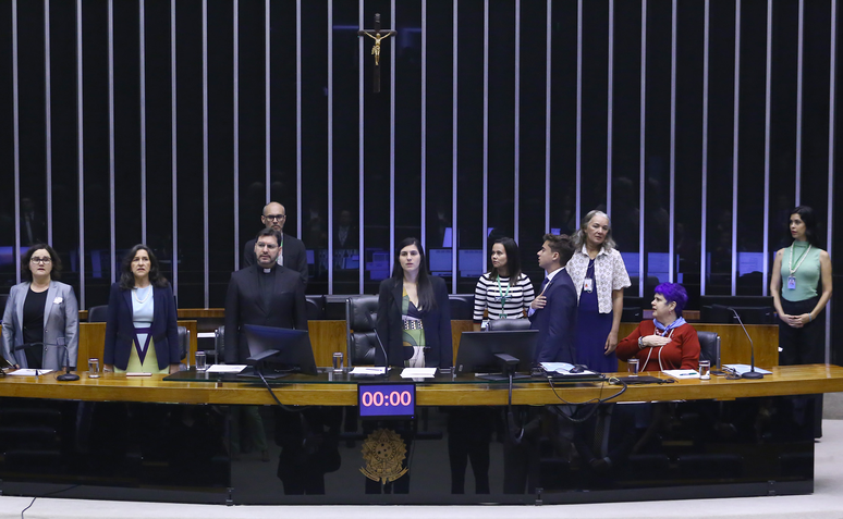 Parlamentares estão de pé diante de mesa da Câmara dos Deputados durante comemoração do Dia do Nascituro