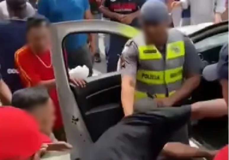 Homem é retirado de dentro de viatura da PM e agredido por grupo na frente de policiais