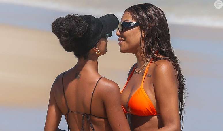 Ludmilla e Brunna Gonçalves trocam beijos na praia.