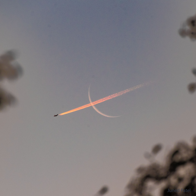 Lua crescente e rastros de condensação deixados por um avião (Imagem: Reprodução/Juned Patel)