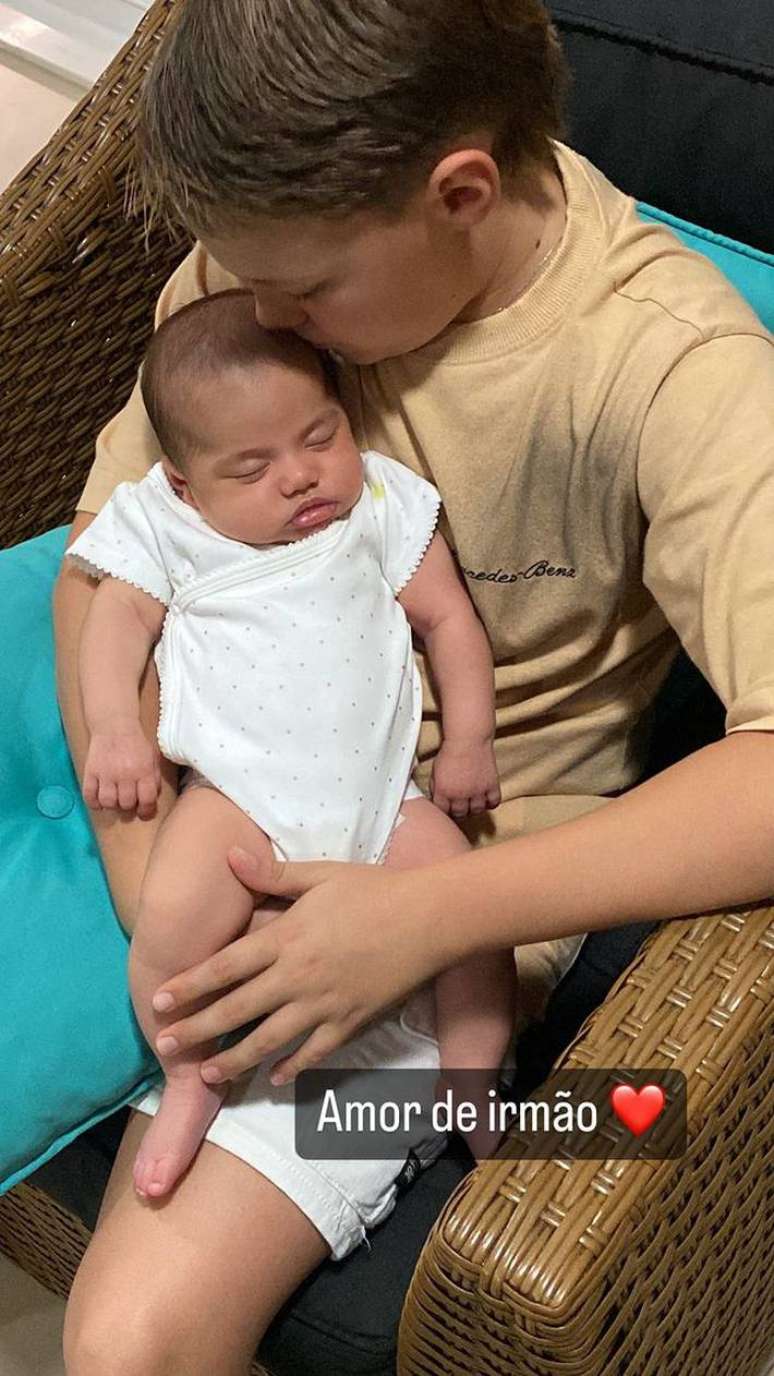 Davi Lucca segura a irm&atilde; mais nova, Mavie, no colo