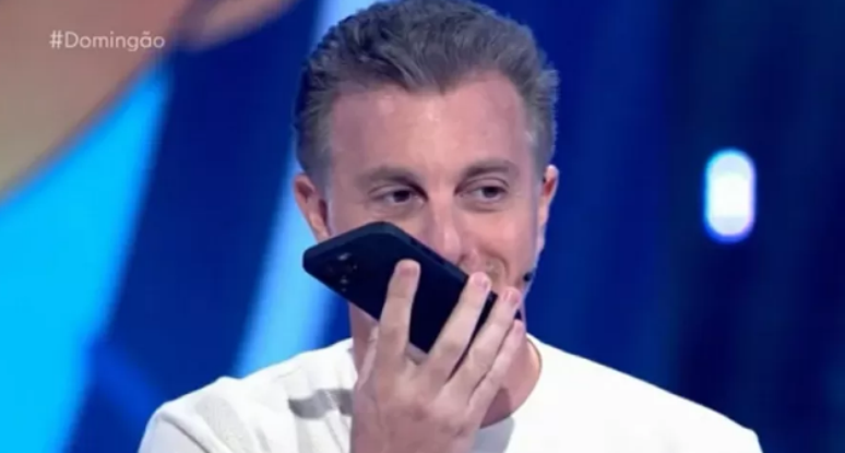 Luciano Huck atentando uma ligação ao vivo no programa Domingão com Huck. 