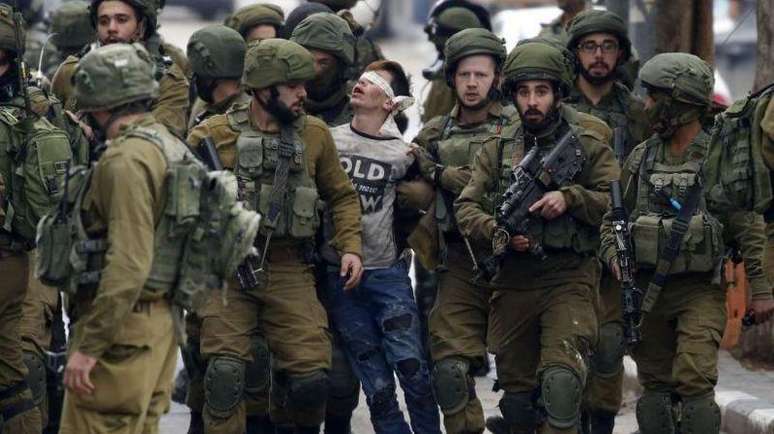 Fawzi al-Juneidi, de 16 anos, se tornou um s&iacute;mbolo da deten&ccedil;&atilde;o de jovens pelo Ex&eacute;rcito israelense quando foi preso em 2017 e fotografado com os olhos vendados