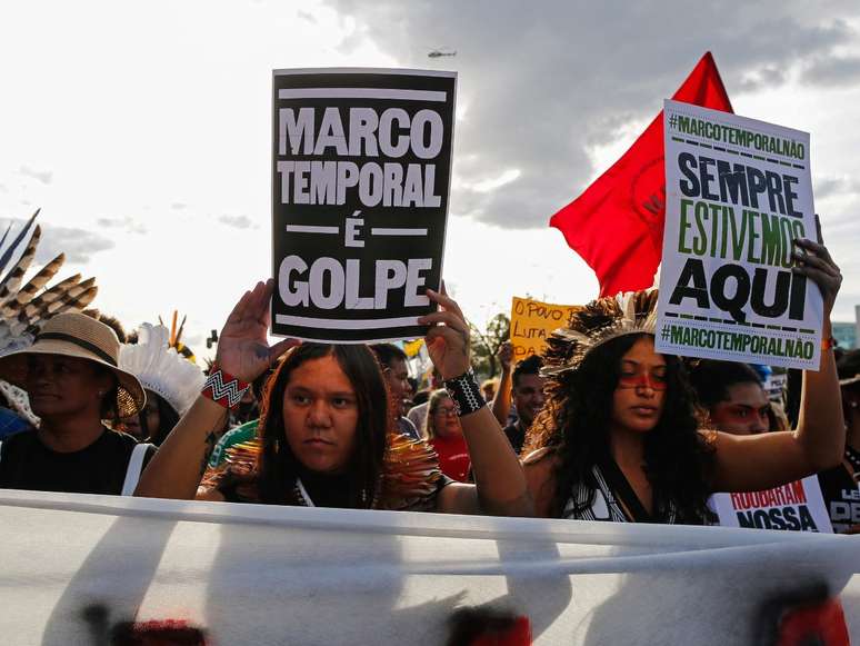 A imagem mostra pessoas indígenas manifestando contra o Marco Temporal