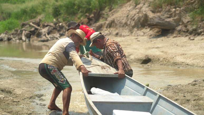 Oliveira e amigos arrastam canoa em leito seco