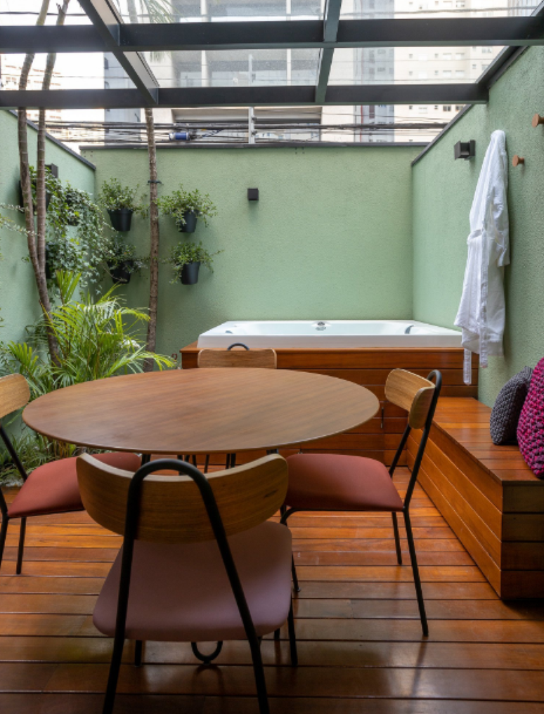 Jacuzzi externa: deck de madeira, área social relaxante e pergolado transparente