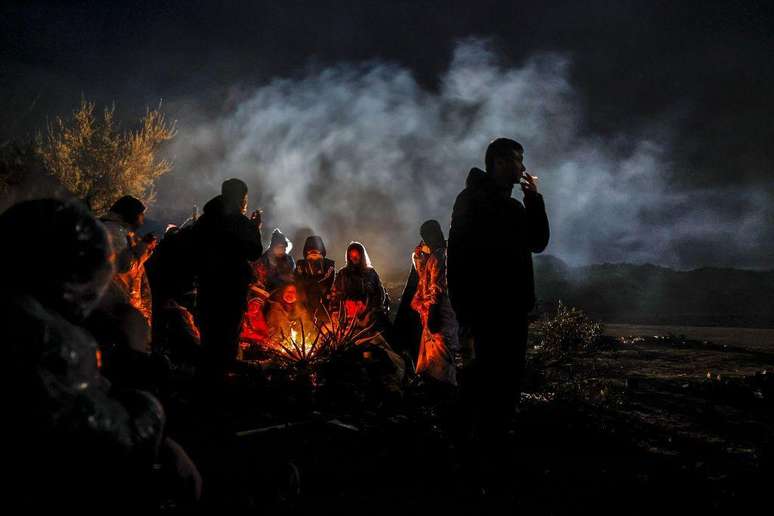 Migrantes cortam arbustos e cactos para acender fogueiras