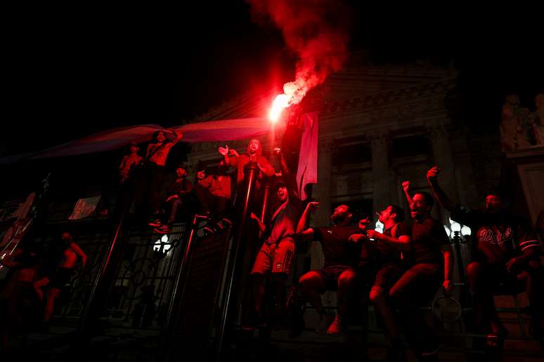 Manifestantes seguram sinalizadores durante protesto contra o novo presidente da Argentina, Javier Milei e a política de ajuste em Buenos Aires (21/12/2023)