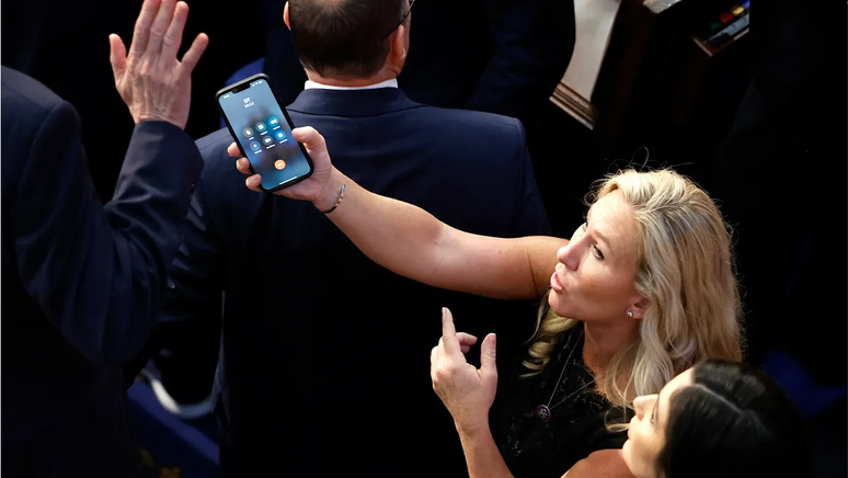Marjorie Taylor Greene segura um telefone com Donald Trump em espera