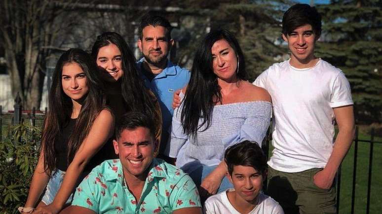 Liam Anand, à direita, com sua mãe Nadine, seu pai Sanjiv e quatro irmãos e irmãs