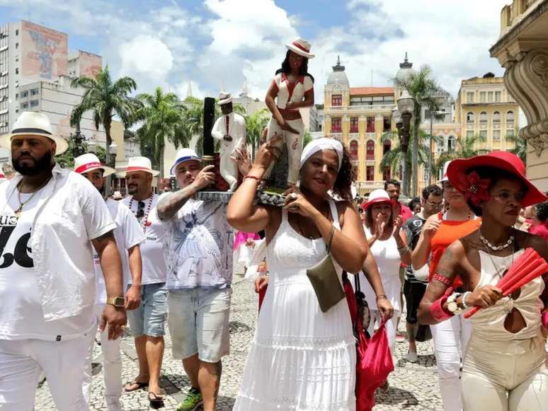 A imagem mostra pessoas negras vestidas de branco durante celebração religiosa