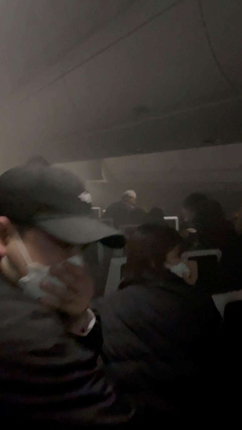 Passageiros usam máscara facial enquanto fumaça toma conta do avião da Japan Airlines