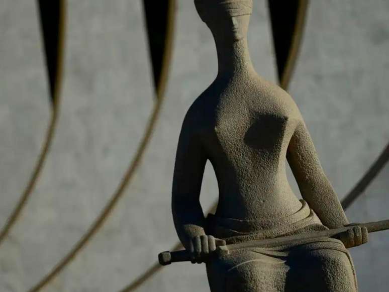 A imagem mostra uma escultura da justiça localizada na Praça dos Três Poderes, onde fica a sede do poder judiciário brasileiro.