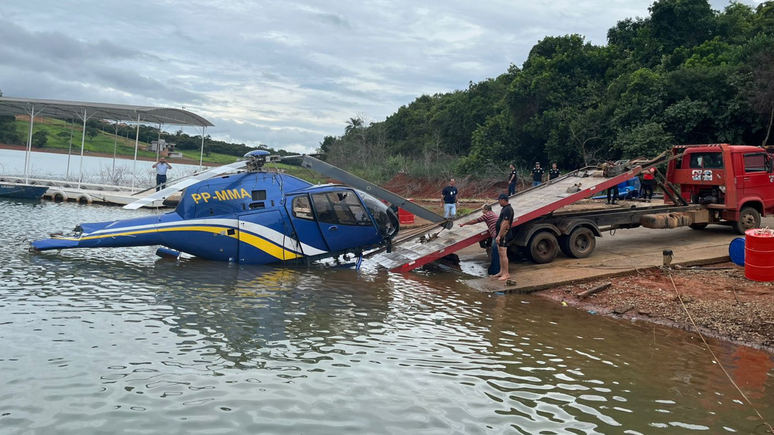 Helicóptero que caiu em MG é retirado da água; veja