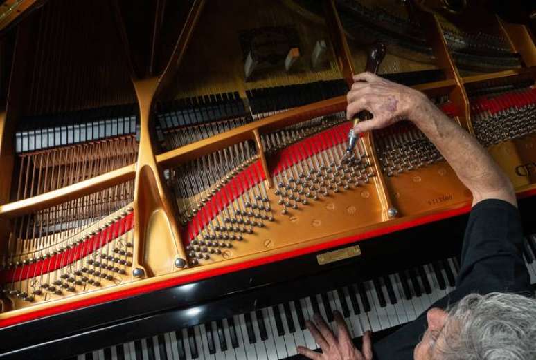 TB SAO PAULO SP 15/12/2023 CADERNO 2 - AFINADOR DE PIANOS/ JOS&Eacute; LUIS DA SILVA - O afinador de pianos Jos&eacute; Lu&iacute;s da Silva ao lado de um piano modelo Steinway da Yamaha, o mesmo utilizado na Sala S&atilde;o Paulo. FOTO TABA BENEDICTO / ESTADAO
