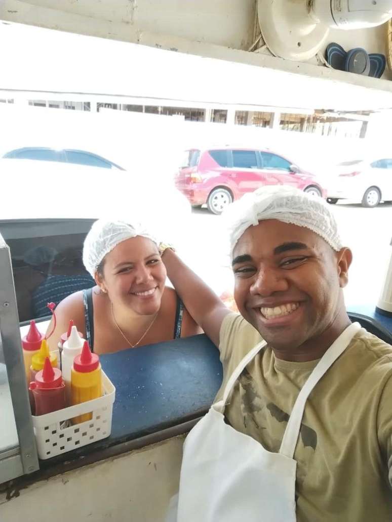 Davi ajuda a mulher Mani a montar os lanches na barraca que ela trabalha em Salvador