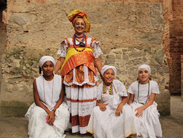 A imagem mostra quatro mulheres negras com vestimentas tradicionais africanas, em material de divulgação do Festival Agbado.