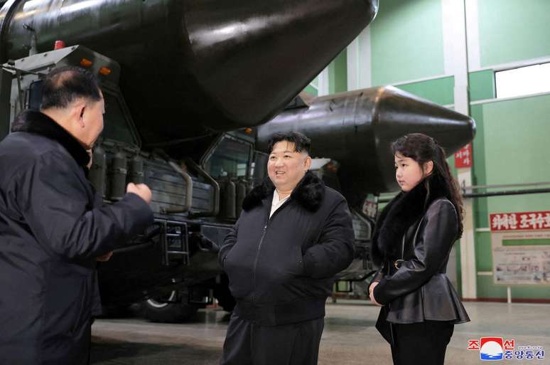 Kim Jong Un e Kim Ju Ae inspecionando uma instalação de produção de lançadores de mísseis em um local não revelado na Coreia do Norte, janeiro de 2024