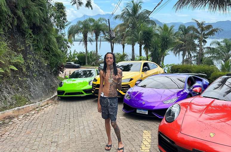 Oruam sets in front of luxury vehicles Oruam sets in front of luxury vehicles