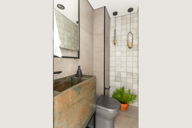 Neste lavabo, o apelo r&uacute;stico do a&ccedil;o corten marca presen&ccedil;a na bancada com cuba esculpida com porcelanato Projeto: BMA Studio |