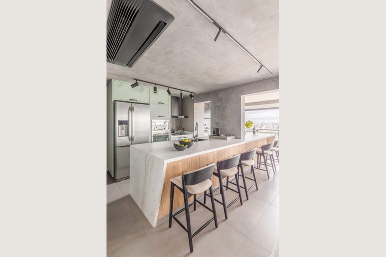 Na bancada que come&ccedil;a na cozinha e se estende at&eacute; a varanda gourmet, o arquiteto&nbsp;investiu na naturalidade do porcelanato Projeto: BMA Studio |