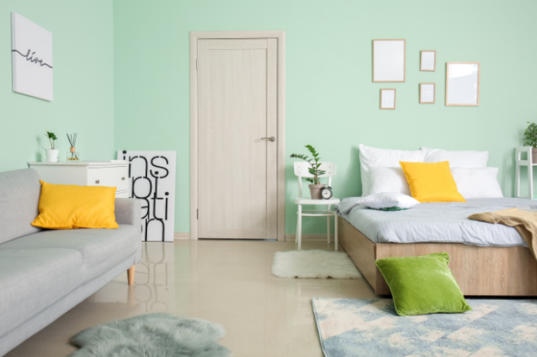 14. Sofá para quarto: toques coloridos em almofadas amarela e verde, trazendo vida ao espaço verde-água – Foto: Shutterstock