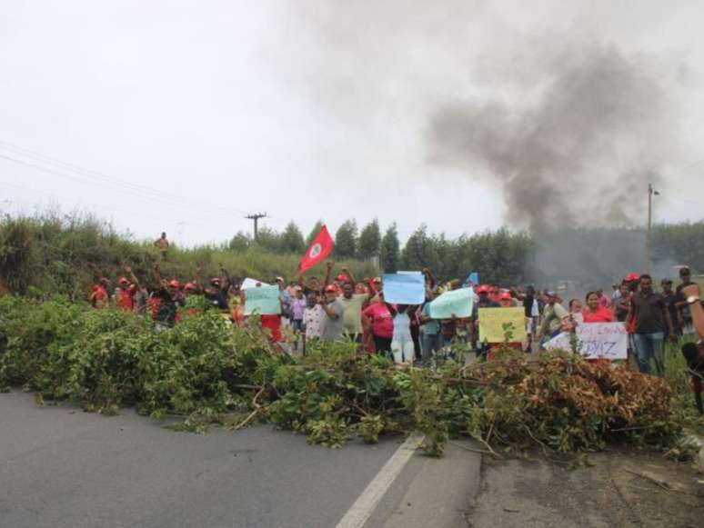 Imagem mostra dezenas de integrantes do Movimento dos Trabalhadores Rurais Sem Terra durante bloqueio na rodovia BR-101 em protesto a ataque indígena.