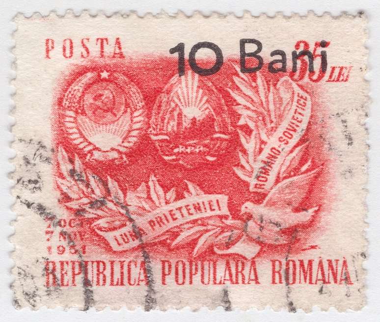 ROMÊNIA - 1952: Selo postal vermelho-alaranjado, representando o brasão de armas da União Soviética e da Romênia, sobretaxado em preto.