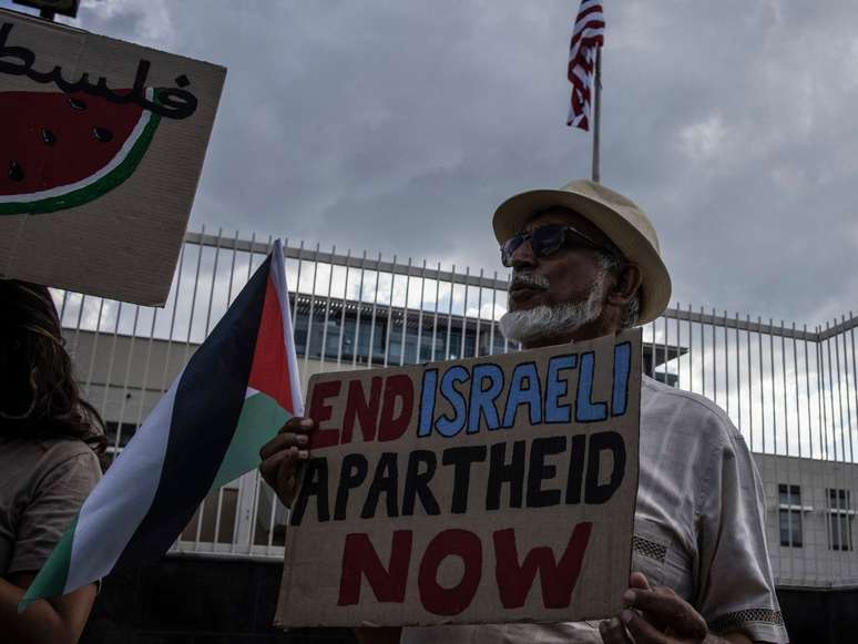 Ativista pró-palestina segura um cartaz com os dizeres "fim do apartheid israelense já", em protesto contra as suas operações militares em Gaza, em 26 de janeiro de 2024.