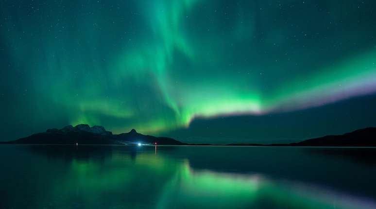 Em Bodø, tons de verde e roxo se misturam no céu estrelado