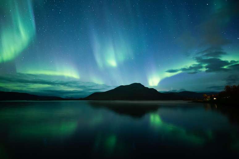 O Lago Kilpisjärvi no vilarejo homônimo arremata a magia da aurora refletindo suas luzes