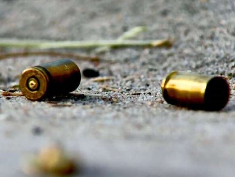 A imagem mostra duas cápsulas de arma de fogo, já deflagradas, no chão.