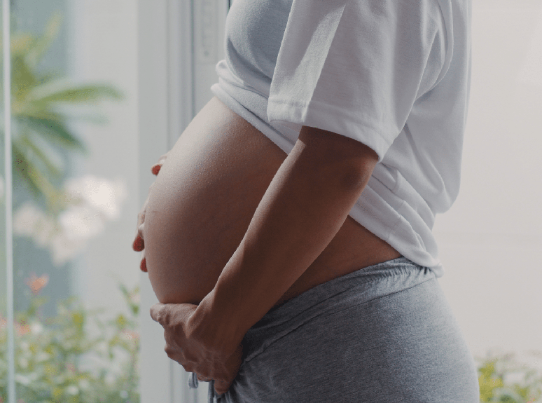 Imagem de mulher grávida segurando a barriga.