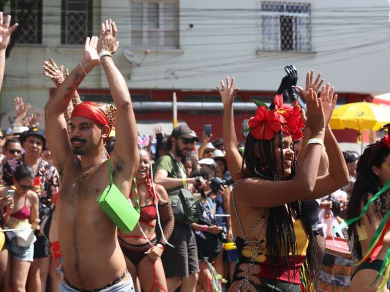 A imagem mostra foliões no carnaval de rua, em blocos que celebram a diversidade.