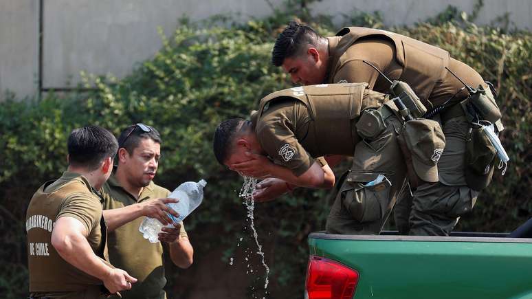 Carabineiros, oficiais de polícia ostensiva chilenos, bebem água e se refrescam em Viña del Mar