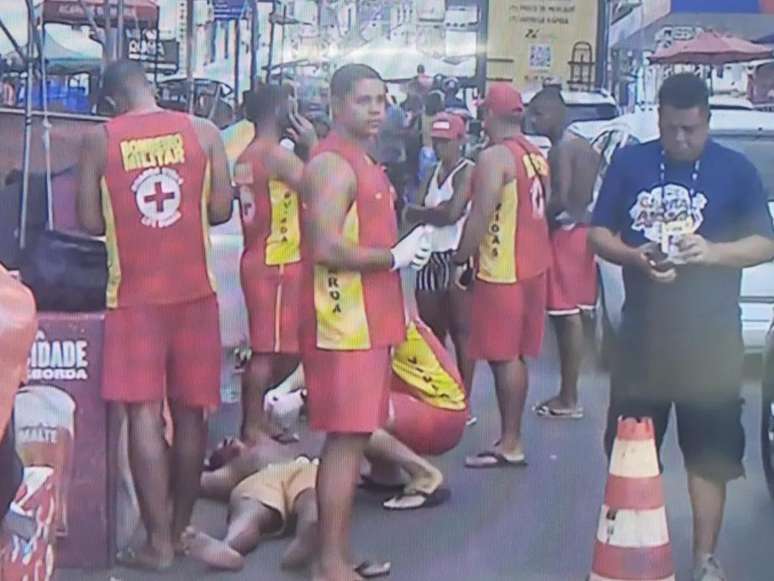 A imagem mostra momento em que os bombeiros resgatam o homem negro violentado em cordão do carnaval de Salvador.