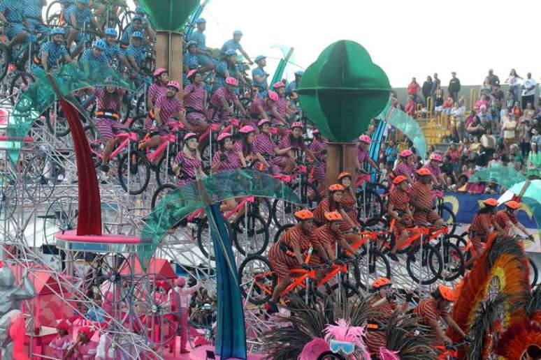 A Rosas de Ouro fechou o primeiro dia de desfiles do Grupo Especial levando o Parque Ibirapuera, que completa 70 anos, para a avenida. Em um dos carros aleg&oacute;ricos, 61 foli&otilde;es pedalavam suspensos entre ferragens.