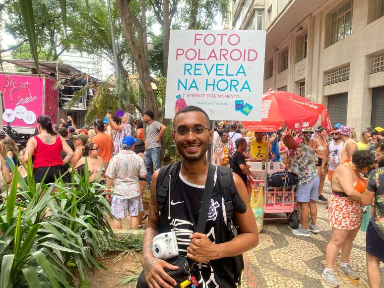 Jovem percorre blocos de SP oferecendo fotos instantâneas