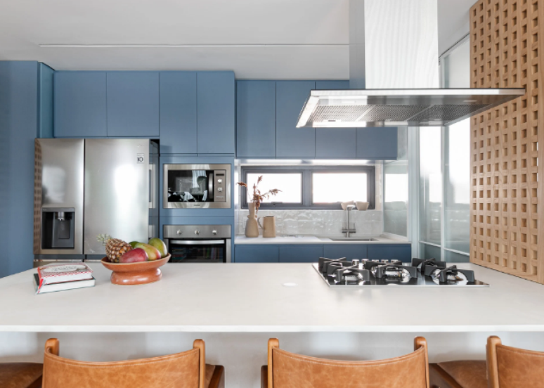 7. Cozinha planejada com marcenaria azul, cooktop a gás e eletrodomésticos de inox, que dão um toque contemporâneo ao ambiente – Projeto: Duda Senna Arquitetura | Foto: Gisele Rampazzo