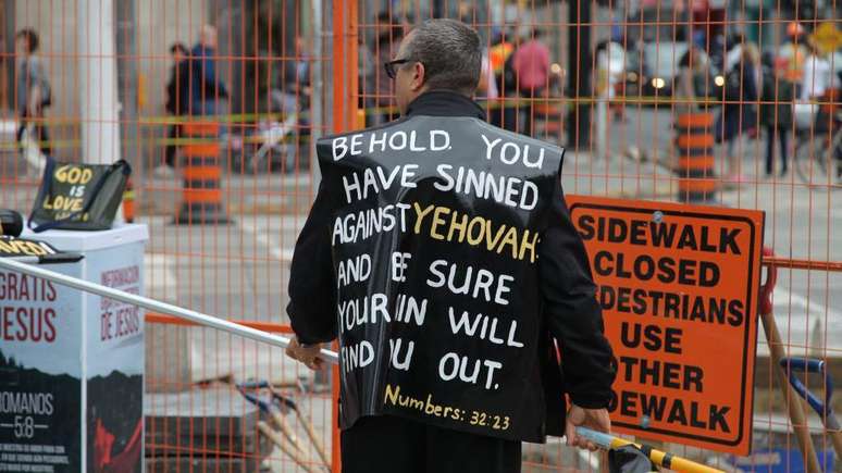 Pregador crist&atilde;o em rua de Toronto, Canad&aacute;, com vestes que citam escrituras b&iacute;blicas