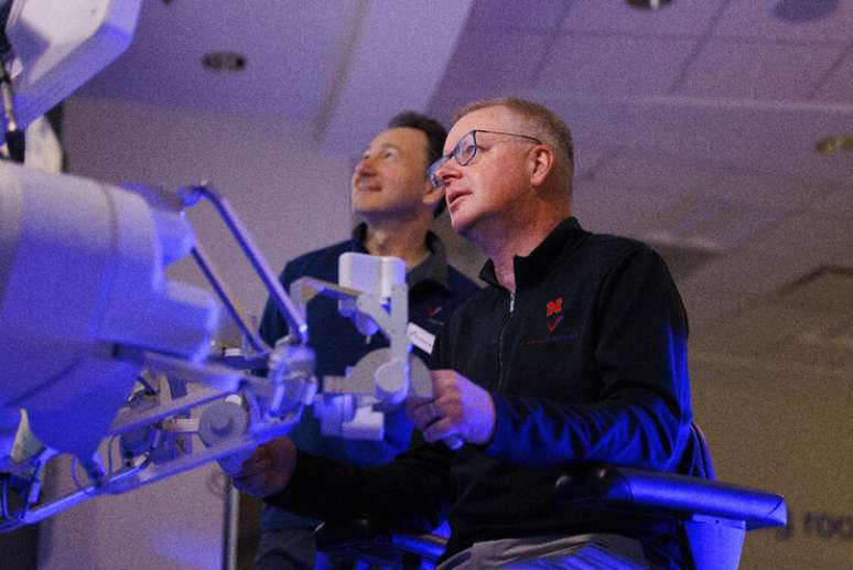 Shane Farritor, professor de engenharia de Nebraska e cofundador da Virtual Incision, se reveza usando o robô cirúrgico enquanto o Dr. Dmitry Oleynikov observa