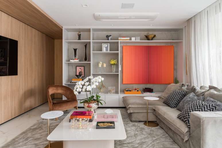 The apartment has a walk-in closet, olive green kitchen and bathroom with chromotherapy. Interior space design. In the photo, living room, red painting, bookcase with niches, beige sofa, wooden veranda, TV panel. The apartment has a walk-in closet, olive green kitchen and bathroom with chromotherapy. Interior space design. In the photo, living room, red painting, bookcase with niches, beige sofa, wooden veranda, TV panel.