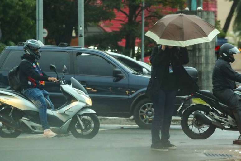 Pedestres se protegem com guarda-chuva na zona sul de São Paulo. Expecativa é de chuva isolada para a capital paulista neste fim de semana.