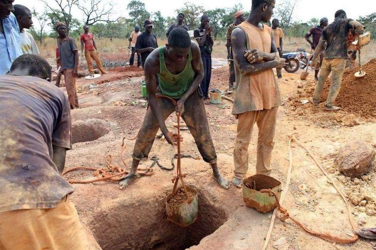 Garimpeiros esvaziam recipientes de terra retirados de uma mina em Koflatie, no Mali, em 28 de outubro de 2014