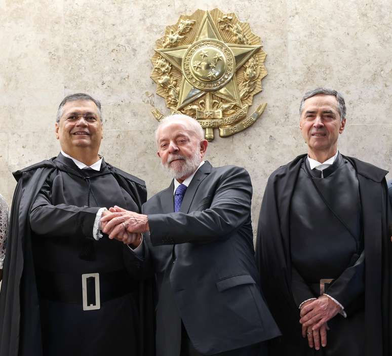 Flávio Dino, novo ministro do STF, ao lado do presidente Luiz Inácio Lula da Silva e do presidente do STF, Luís Roberto Barroso.