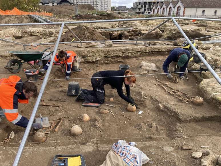 Arqueólogos trabalhando na vala comum encontrada no sítio arqueológico da Abadia de Beaumont (Imagem: Jean Demerliac/Inrap)