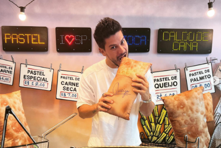 Ator, cantor e ex-participante do BBB22, Arthur Aguiar, realizando uma publicidade em uma pastelaria.