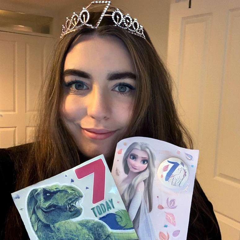 Júlia mostra seus cartões com o número 7 em seu sétimo aniversário em ano bissexto