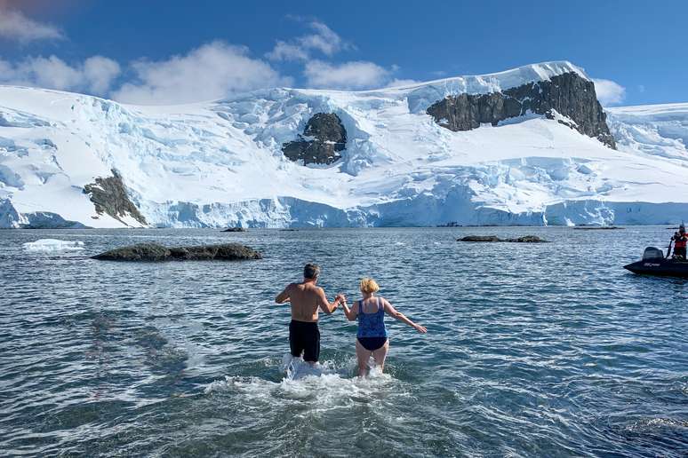 casal realizando um mergulho polar na Antártida. 